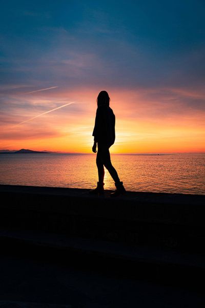 woman walking against sunset